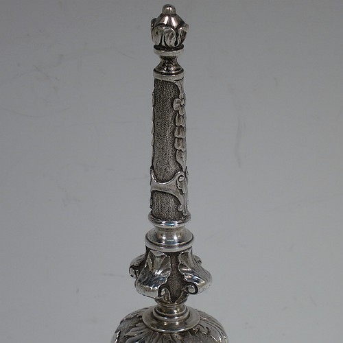 A very handsome, large and heavy sterling silver table bell having a round baluster body with hand-chased acanthus-leaf, scroll and floral decoration, a cast floral and scroll handle, and an original silver clapper. Made in London in 1967. The dimensions of this fine hand-made silver table bell are height 18 cms (7 inches), diameter at base 7 cms (2.75 inches), and it weighs approx. 361g (11.6 troy ounces).   