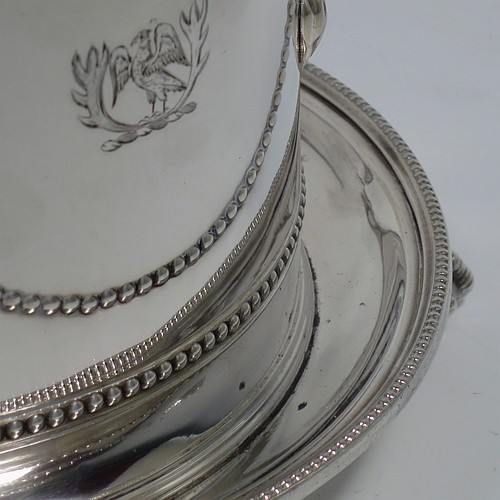 An Antique Victorian Silver Plated biscuit box, having a round body with applied bead-edged borders, straight sides and hand-chased swags of bead-work in a neoclassical style, a hinged domed lid with cast finial, and all sitting on an attached plate with three cast claw and ball feet. Made by James Thompson of Sheffield in ca. 1880. The dimensions of this fine hand-made antique silver-plated biscuit box are height 18 cms (7 inches), and diameter at base 18 cms (7 inches). Please note that this item is crested.