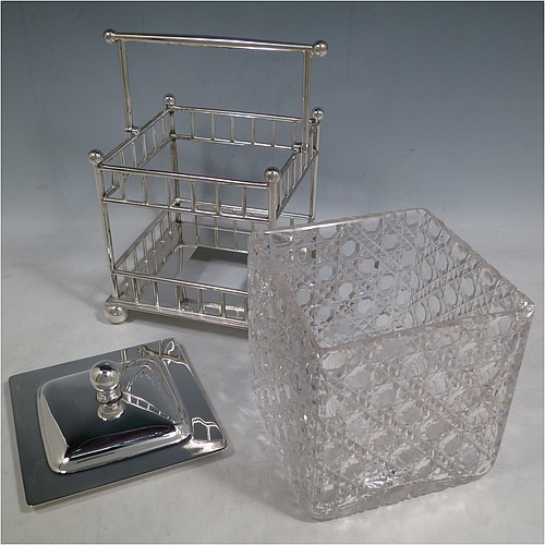 An Antique Victorian silver plated and cut crystal biscuit jar, having a hobnail cut square crystal jar with straight sides, a plain lift-off lid with ball finial, all inside a galleried wire-work frame with swing handle, and sitting on a base with four ball feet. Made by the Atkins Brothers of Sheffield in ca. 1880. The dimensions of this fine hand-made antique silver-plated and hand-cut crystal biscuit jar are height inc. handle 20 cms (8 inches), and 14 cms (5.5 inches) square.    