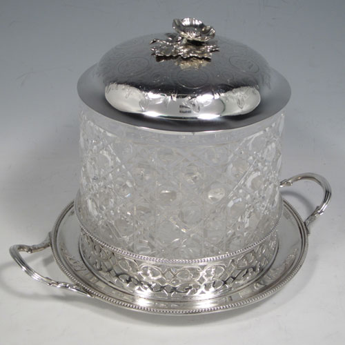 Antique Victorian sterling silver and hand-cut crystal biscuit jar, having a hobnail cut body, a lift-off lid with hand-engraved floral work and a cast flower finial, all sitting inside a two-handled plate with a hand-pierced gallery and bead-edge border. Made by Henry Wilkinson and Co., of Sheffield in 1867. The dimensions of this fine hand-made silver and crystal biscuit box are height 18 cms (6.3 inches), and diameter of base 17 cms (6.75 inches).