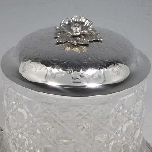 Antique Victorian sterling silver and hand-cut crystal biscuit jar, having a hobnail cut body, a lift-off lid with hand-engraved floral work and a cast flower finial, all sitting inside a two-handled plate with a hand-pierced gallery and bead-edge border. Made by Henry Wilkinson and Co., of Sheffield in 1867. The dimensions of this fine hand-made silver and crystal biscuit box are height 18 cms (6.3 inches), and diameter of base 17 cms (6.75 inches).