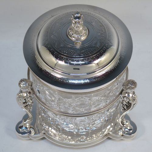 A very pretty Antique Victorian silver-plated and hand-cut crystal biscuit jar, having a hobnail and star cut body, a hinged lid with hand-engraved floral work and a cast leopards head finial, all sitting inside a galleried base with three cast caryatid figures attached to a central band and sitting on three cushion feet, all with bead-edge borders. Made by Henry Atkins of Sheffield in ca. 1880. The dimensions of this fine hand-made silver plated and crystal biscuit box are height 21.5 cms (8.5 inches), and diameter of base 15 cms (6 inches).  