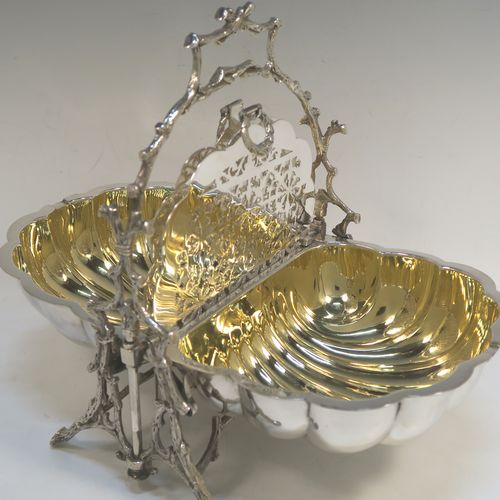 A beautiful Antique Victorian Silver Plated double folding biscuit box, having a plain shell-style body sitting in a cast tree branch designed frame, with a gold-gilt interior and original hand-pierced dividers. This very pretty antique plated biscuit box was made by James Dixon and Sons of Sheffield in ca. 1880. The dimensions of this fine hand-made antique silver-plated folding biscuit box are height 26 cms (10.25 inches), length fully opened 32 cms (12.5 inches), and width 20 cms (8 inches).   