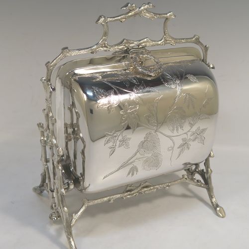 A very pretty Antique Victorian Silver Plated folding biscuit box, having an oval barrel-shaped body with beautiful hand-engraved floral decoration, sitting in a cast tree log style mechanical frame with carrying handle, and with original gold-gilt interior with hand-pierced dividers. This beautiful antique silver-plated folding biscuit box was made in ca. 1880. The dimensions of this fine hand-made silver-plated folding biscuit box are height 24 cms (9.5 inches), length fully opened 30.5 cms (12 inches), and width 20 cms (8 inches).   