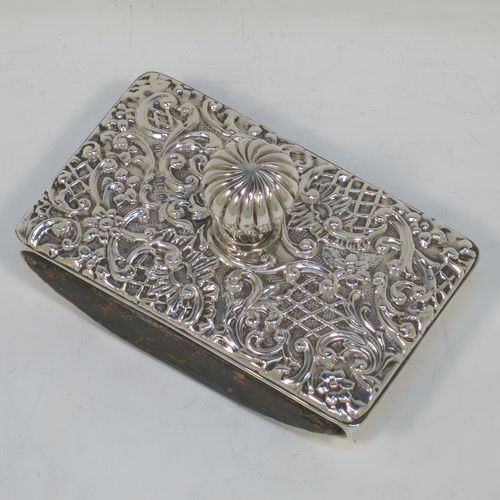 A very pretty Antique Edwardian Sterling Silver Rocker Blotter, having a rectangular body with rounded corners and hand-chased floral and scroll decoration, a leather covered rocker base, and a swirl fluted round handle that screws in to secure the rocker base and blotting paper to the upper body. Made by Henry Miller of Birmingham in 1902. The dimensions of this fine hand-made antique silver rocker blotter are length 11.5 cms (4.5 inches), height 6.5 cms (2.5 inches), and width 7 cms (2.75 inches).  