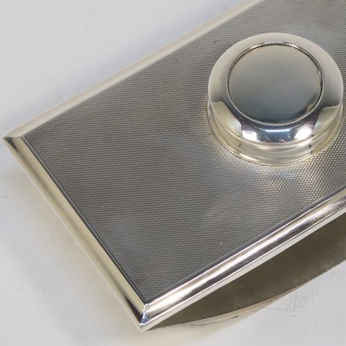 A handsome and unusual Sterling Silver Rocker Blotter, having a rectangular body with engine-turned decoration and plain chamfered borders, a plain round central handle, and a sprung steel plate held under tension that holds the blotting paper to the upper body. This beautiful silver rocker blotter was made by Turner and Simpson of Birmingham in 1956. The dimensions of this fine hand-made silver rocker blotter are length 15 cms (6 inches), height 5 cms (2 inches), width 8.5 cms (3.25 inches), and it weighs approx. 150g (4.8 ozt).   