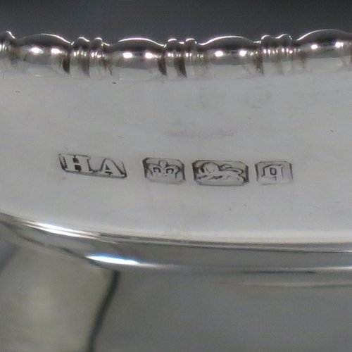 An Antique Sterling Silver pair of bon-bon dishes, having plain oval bodies, with applied and shaped egg & dart borders, and sitting on pedestal feet. Made by Henry Atkins of Sheffield in 1911. The dimensions of this fine pair of hand-made silver bon-bon dishes are length 16 cms (6.3 inches), width 11.5 cms (4.5 inches), height 8 cms (3 inches), and they weigh a total of approx. 413g (13.3 troy ounces).   