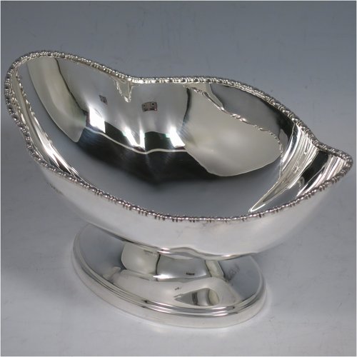 An Antique Sterling Silver pair of bon-bon dishes, having plain oval bodies, with applied and shaped egg & dart borders, and sitting on pedestal feet. Made by Henry Atkins of Sheffield in 1911. The dimensions of this fine pair of hand-made silver bon-bon dishes are length 16 cms (6.3 inches), width 11.5 cms (4.5 inches), height 8 cms (3 inches), and they weigh a total of approx. 413g (13.3 troy ounces).   