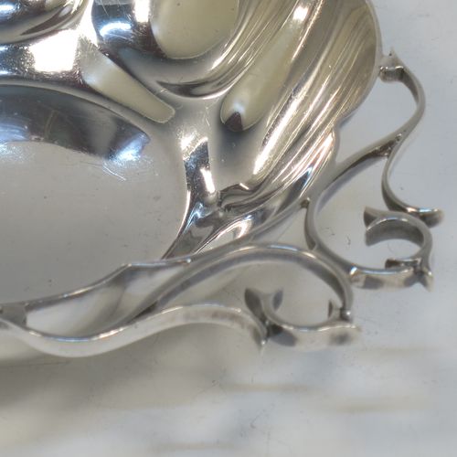 A very pretty Antique Edwardian Sterling Silver pair of bon-bon dishes, having rounded bodies with hand-chased lobed decoration, with beautiful scroll work side-handles, and all sitting on flat bases. Made by Roberts and Belk of Sheffield in 1908. The dimensions of this fine hand-made pair of antique silver bon-bon dishes  are length (inc. handles) 16 cms (6.25 inches), diameter 12 cms (4.75 inches), height 3.5 cms (1.3 inches), and they weigh a total of approx. 310g (10 troy ounces).   