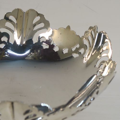 A pretty pair of Sterling Silver bon-bon dishes, having round bodies, with hand-pierced and wavey edge top borders, and sitting on plain round pedestal feet. These elegant silver bon-bon dishes were made by Emile Viner of Sheffield in 1958. The dimensions of these fine hand-made silver bon-bon dishes are height 7 cms (2.75 inches), diameter 11 cms (4.3 inches), and they weigh a total of approx. 212g (6.8 troy ounces).   