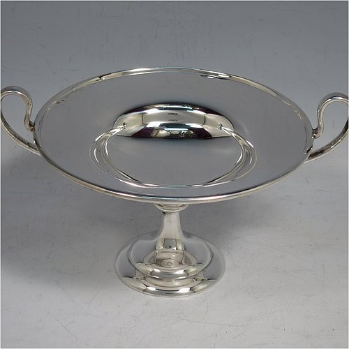 An Antique Edwardian Sterling Silver pair of bon-bon dishes, having plain round bodies, with applied reeded borders and two looped side handles, all raised above and sitting on plain round pedestal feet. Made by Holland, Aldwinkle & Slater  of London in 1907. The dimensions of these fine hand-made antique silver bon-bon dishes are height 9 cms (3.5 inches), diameter 11.5 cms (4.5 inches), and they weigh a total of approx. 241g (7.8 troy ounces).    