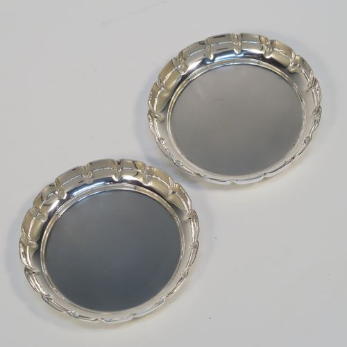 An elegant Sterling Silver pair of bon-bon dishes, having plain round bodies, with hand-chased scalloped raised borders, and sitting on flat bases. This handsome pair of silver bon-bon dishes were made by Bryan Savage of London in 1973. The dimensions of these fine hand-made silver bon-bon dishes are height 1.5 cms (0.5 inches), diameter 9 cms (3.5 inches), and they weigh a total of approx. 112g (3.6 troy ounces).   