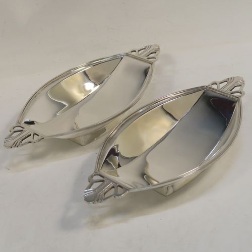 A pair of fine Art Deco style Sterling Silver bon-bon dishes, having plain oval paneled bodies, with reeded borders and hand-pierced side handles, and sitting on collet feet. These elegant silver bon-bon dishes were made by Mappin and Webb of Birmingham in 1937. The dimensions of these fine hand-made silver bon-bon dishes are length 21 cms (8.25 inches), width 10 cms (4 inches), height 3.5 cms (1.3 inches), and with a total weight of approx. 287g (9.3 troy ounces).   