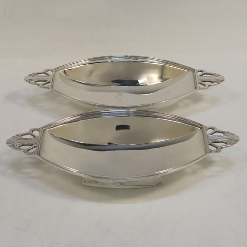 A pair of fine Art Deco style Sterling Silver bon-bon dishes, having plain oval paneled bodies, with reeded borders and hand-pierced side handles, and sitting on collet feet. These elegant silver bon-bon dishes were made by Mappin and Webb of Birmingham in 1937. The dimensions of these fine hand-made silver bon-bon dishes are length 21 cms (8.25 inches), width 10 cms (4 inches), height 3.5 cms (1.3 inches), and with a total weight of approx. 287g (9.3 troy ounces).   