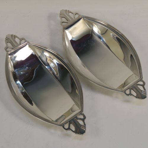 A pair of fine Art Deco style Sterling Silver bon-bon dishes, having plain oval paneled bodies, with reeded borders and hand-pierced side handles, and sitting on collet feet. These elegant silver bon-bon dishes were made by Mappin and Webb of Birmingham in 1937. The dimensions of these fine hand-made silver bon-bon dishes are length 21 cms (8.25 inches), width 10 cms (4 inches), height 3.5 cms (1.3 inches), and with a total weight of approx. 287g (9.3 troy ounces).   