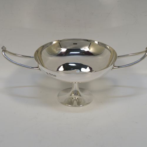 A very elegant Antique Edwardian Sterling Silver bon-bon dish, in an Arts and Crafts style having a plain round body, with two Aladdin lamp style side-handles, and siting on a on a plain round pedestal foot. This handsome silver bon-bon dish was made by Joseph Hemming of London in 1902. The dimensions of this fine hand-made antique silver bon-bon dish are height 9 cms (3.5 inches), diameter 11.5 cms (4.5 inches), and they weigh a total of approx. 210g (6.8 troy ounces).   