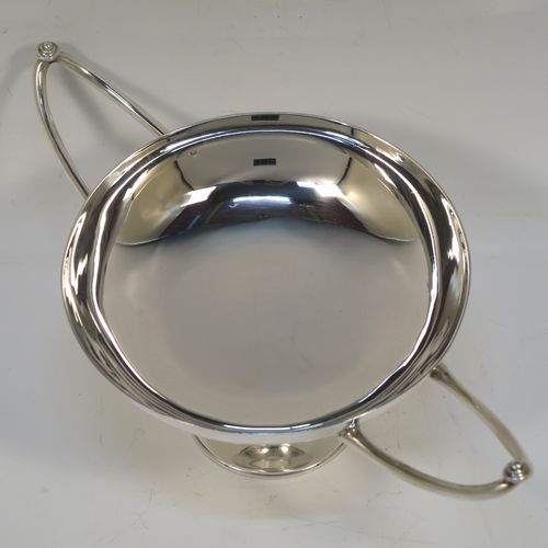 A very elegant Antique Edwardian Sterling Silver bon-bon dish, in an Arts and Crafts style having a plain round body, with two Aladdin lamp style side-handles, and siting on a on a plain round pedestal foot. This handsome silver bon-bon dish was made by Joseph Hemming of London in 1902. The dimensions of this fine hand-made antique silver bon-bon dish are height 9 cms (3.5 inches), diameter 11.5 cms (4.5 inches), and they weigh a total of approx. 210g (6.8 troy ounces).   