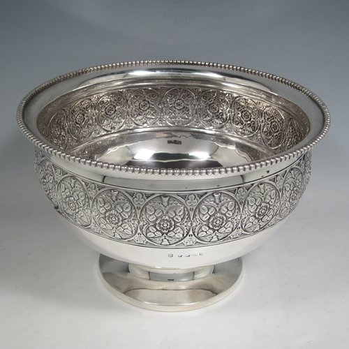 Antique Victorian sterling silver large table rose bowl, having a round body with a hand-chased band of floral decoration, an applied bead-edged border, and all sitting on a pedestal foot. Made by Edgar Finlay & Hugh Taylor of Birmingham in 1888. The dimensions of this fine hand-made silver bowl are diameter 24 cms (9.5 inches), height 16 cms (6.25 inches), and it weighs approx. 752g (24 troy ounces).   