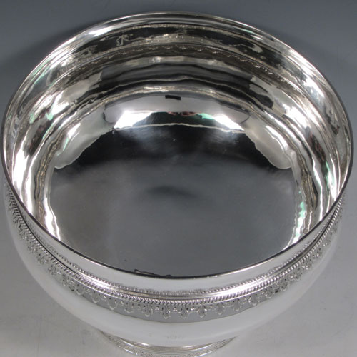 Antique Victorian sterling silver large table bowl, having a round plain baluster body, with a band of hand-chased anthemion leaves below a gadroon rope-twist border, sitting on a pedestal foot with matching decoration. Made by Charles Stuart Harris of London in 1893. The dimensions of this fine hand-made silver bowl are diameter at lip 23 cms (9 inches), height 18.5 cms (7.25 inches), and it weighs approx. 1,141g (36.8 troy ounces).