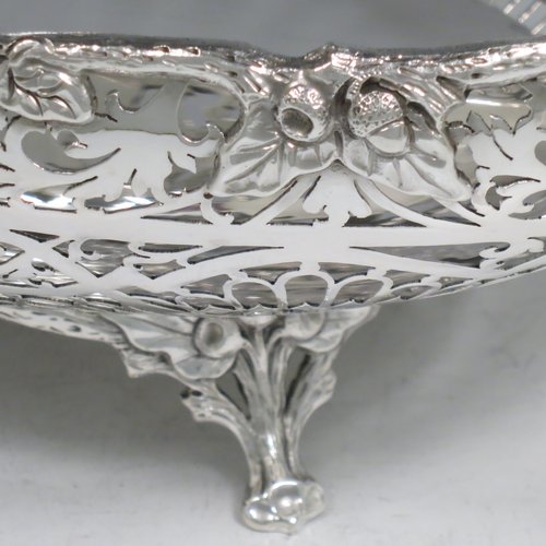 A Sterling Silver large table bowl, having an oval body with hand-pierced floral decoration, an applied cast border with oak-leaf mounts, with two cast loop handles, and all sitting on four cast foliate feet with matching decoration. Made by Robert Pringle of Sheffield in 1951. The dimensions of this fine hand-made silver bowl are length 32 cms (12.5 inches), width 20 cms (8 inches), height 14 cms (5.5 inches), and it weighs approx. 898g (29 troy ounces).   