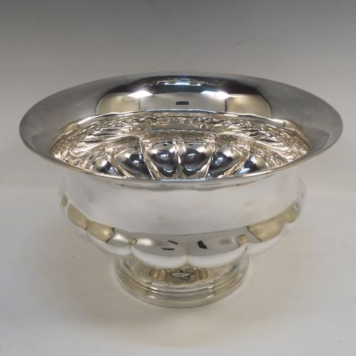 A rare and very elegant Antique late Georgian Sterling Silver large table bowl, having a round bellied body with a lower band of hand-chased melon-style fluting, and all sitting on a round pedestal foot. This beautiful antique silver table bowl was made by Joseph Cradock of London in 1828. The dimensions of this fine hand-made antique silver bowl are diameter 30.5 cms (12 inches), height 18.5 cms (7.3 inches), and it weighs approx. 1,222g (39.4 troy ounces).   