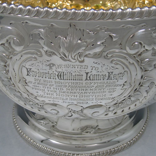 Antique Victorian sterling silver large table bowl, having a round hand-chased body with floral decoration, applied gardroon edge borders, gold-gilt interior, and sitting on a pedestal foot. Made by Henry Atkins of Sheffield in 1901. The dimensions of this fine hand-made silver table bowl are diameter 33 cms (13 inches), height 22.5 cms (8.75 inches), and it weighs approx. 1,548g (50 troy ounces). Please note that one cartouche is engraved with a contemporaneous presentation inscription.