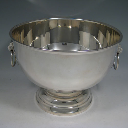 A handsome and large Sterling Silver bowl, having a plain round body, two cast lion-mask ring handles, and sitting on a pedestal foot. This elegant silver table bowl was made in Birmingham in 1972. The dimensions of this fine hand-made silver bowl are diameter 26 cms (10.25 inches), height 19 cms (7.5 inches), and it weighs approx. 1,234g (39.8 troy ounces).