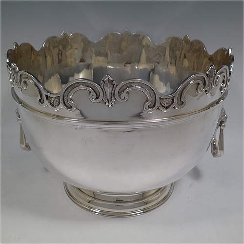 A very handsome and large Antique Edwardian Sterling Silver Montieth style bowl, having a plain round body with an applied scroll border, together with two cast lion-mask side-handles, and sitting on a pedestal foot. Made by William Comyns of London in 1902. The dimensions of this fine hand-made antique silver Montieth table bowl are diameter 31 cms (12 inches), height 23 cms (9 inches), and it weighs approx. 2,440g (78.7 troy ounces).    