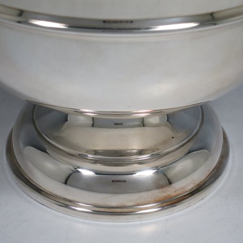 A Sterling Silver table bowl, having a round plain body, with an applied central band, and sitting on a matching pedestal foot. Made in Birmingham in 1930. The dimensions of this fine hand-made silver bowl are diameter 24 cms (9.5 inches), height 18.5 cms (7.25 inches), and it weighs approx. 807g (26 troy ounces).    