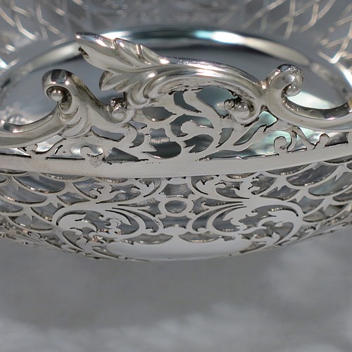 An Antique Edwardian Sterling Silver table bowl, having a round body with hand-pierced floral decoration, an applied floral & scroll border, and all sitting on four cast foliate feet. Made by Mappin & Webb of Sheffield in 1906. The dimensions of this fine hand-made antique silver bowl are diameter 24.5 cms (9.75 inches), height 14 cms (5.5 inches), and it weighs approx. 712g (23 troy ounces).