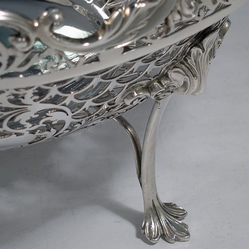 An Antique Edwardian Sterling Silver table bowl, having a round body with hand-pierced floral decoration, an applied floral & scroll border, and all sitting on four cast foliate feet. Made by Mappin & Webb of Sheffield in 1906. The dimensions of this fine hand-made antique silver bowl are diameter 24.5 cms (9.75 inches), height 14 cms (5.5 inches), and it weighs approx. 712g (23 troy ounces).