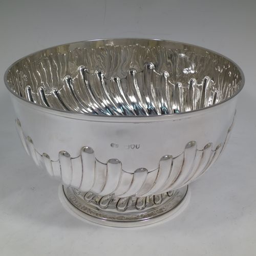 A very nice quality Antique Victorian Sterling Silver Rose bowl, having a round body with hand-chased half swirl-fluted decoration, an applied reeded rim, and sitting on a pedestal foot with matching fluting. Made by John Frank Hall of London in 1895. The dimensions of this fine hand-made antique silver rose bowl are diameter 26 cms (10.25 inches), height 16 cms (6.25 inches), and it weighs approx. 945g (30 troy ounces).    