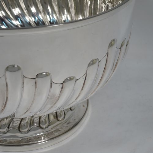 A very nice quality Antique Victorian Sterling Silver Rose bowl, having a round body with hand-chased half swirl-fluted decoration, an applied reeded rim, and sitting on a pedestal foot with matching fluting. Made by John Frank Hall of London in 1895. The dimensions of this fine hand-made antique silver rose bowl are diameter 26 cms (10.25 inches), height 16 cms (6.25 inches), and it weighs approx. 945g (30 troy ounces).    