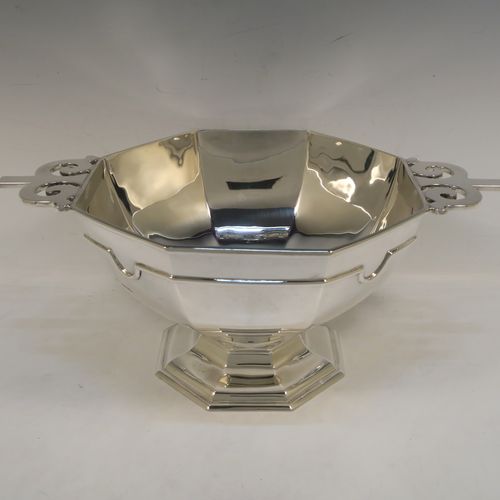 A very handsome Antique Sterling Silver large table bowl, having a plain octagonal panelled body with an applied reeded upper band, together with cast hand-pierced flat scroll handles, and all sitting on a matching pedestal foot. This handsome antique silver bowl was made by Johnson, Walker, and Tolhurst of Sheffield in 1919. The dimensions of this fine hand-made large silver table bowl are diameter 24 cms (9.5 inches), height 15 cms (6 inches), and it weighs approx. 1,269g (41 troy ounces).   