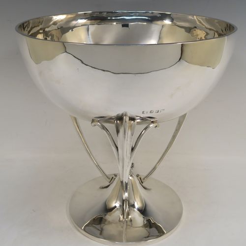 A very handsome Scottish Antique Sterling Silver Art Nouveau style table bowl, having a plain round and bellied body, with three cast scroll and tendril supports attached to a pedestal foot with a central finial. This elegant silver table bowl was made by David and George Edward of Glasgow in 1915. The dimensions of this fine hand-made Art Nouveau Scottish silver bowl are height 27 cms (10.5 inches), diameter at top of bowl 25.5 cms (10 inches), and it weighs approx. 1,535g (49.5 troy ounces).  