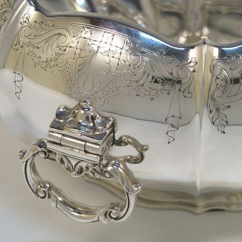 A very pretty and unusual Sterling Silver table bowl, having a round bellied body with a hand-engraved upper border showing scroll and floral decoration over hand-chased melon fluting, with two cast and hinged side handles, and all sitting on a pedestal foot. This beautiful silver bowl was made by Mappin and Webb of Sheffield in 1934. The dimensions of this fine hand-made silver bowl are diameter 25.5 cms (10 inches), height 12.5 cms (5 inches), and it weighs approx. 1,304g (42 troy ounces).  