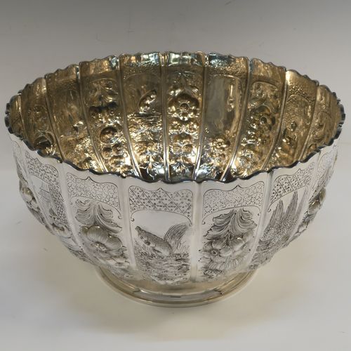 A very unusual and beautiful Antique Victorian Sterling Silver large Rose bowl, having a round panelled body with hand-chased floral and figural decoration, a wavy-edge top border and a gold-gilt interior, and all sitting on a round pedestal foot. This amazing antique silver bowl was made by Francis Boone Thomas of London in 1899. The dimensions of this fine hand-made antique silver large table bowl are diameter 30 cms (11.75 inches), height 17cms (6.75 inches), and it weighs approx. 1,286g (41.5 troy ounces).   