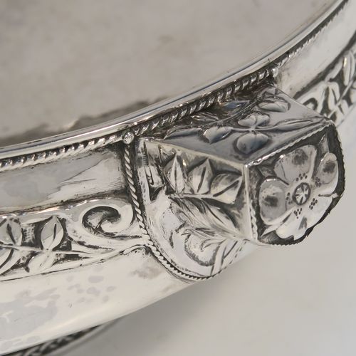 A very unusual and beautiful Antique Sterling Silver Art and Crafts style table bowl, having a round bellied body with hand-hammered decoration, an applied rope-twist top border, together with an applied central band of leaf design work, with three matching side-handles, and all sitting on a pedestal foot. This superb Arts and Crafts style  silver table bowl was made by John Sydney Reeve of  Birmingham in 1912. The dimensions of this fine hand-made antique silver bowl are height 8.5 cms (3.3 inches), diameter at top of bowl 24 cms (9.5 inches), and it weighs approx. 799g (25.8 troy ounces).   