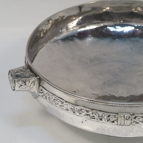 A very unusual and beautiful Antique Sterling Silver Art and Crafts style table bowl, having a round bellied body with hand-hammered decoration, an applied rope-twist top border, together with an applied central band of leaf design work, with three matching side-handles, and all sitting on a pedestal foot. This superb Arts and Crafts style  silver table bowl was made by John Sydney Reeve of  Birmingham in 1912. The dimensions of this fine hand-made antique silver bowl are height 8.5 cms (3.3 inches), diameter at top of bowl 24 cms (9.5 inches), and it weighs approx. 799g (25.8 troy ounces).   