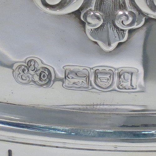 An Antique Edwardian Sterling Silver Montieth style bowl, having a round body with an applied scroll border, with hand-chased half-fluted decoration, together with two cast lion-mask side-handles, and sitting on a pedestal foot. Made by Elkington & Co.,of London in 1910. The dimensions of this fine hand-made antique silver table bowl are diameter 22 cms (8.75 inches), height 16.5 cms (6.5 inches), and it weighs approx. 930g (30 troy ounces).    