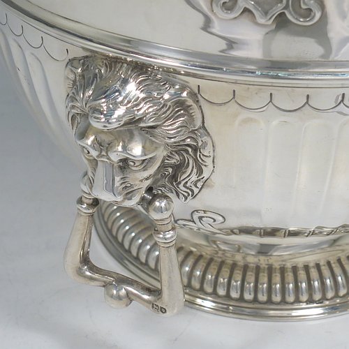 An Antique Edwardian Sterling Silver Montieth style bowl, having a round body with an applied scroll border, with hand-chased half-fluted decoration, together with two cast lion-mask side-handles, and sitting on a pedestal foot. Made by Elkington & Co.,of London in 1910. The dimensions of this fine hand-made antique silver table bowl are diameter 22 cms (8.75 inches), height 16.5 cms (6.5 inches), and it weighs approx. 930g (30 troy ounces).    