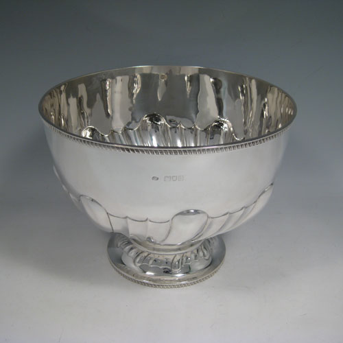 Antique Edwardian sterling silver bowl, having a round hand-chased body with large swirl-fluting, a matching pedestal foot, and applied gadroon borders. Made by Charles Boyton of London in 1903. The dimenions of this fine silver bowl are height 17 cms (6.75 inches), diameter 23 cms (9 inches), and it weighs approx. 770g (24.8 troy ounces).