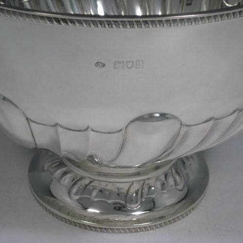 Antique Edwardian sterling silver bowl, having a round hand-chased body with large swirl-fluting, a matching pedestal foot, and applied gadroon borders. Made by Charles Boyton of London in 1903. The dimenions of this fine silver bowl are height 17 cms (6.75 inches), diameter 23 cms (9 inches), and it weighs approx. 770g (24.8 troy ounces).