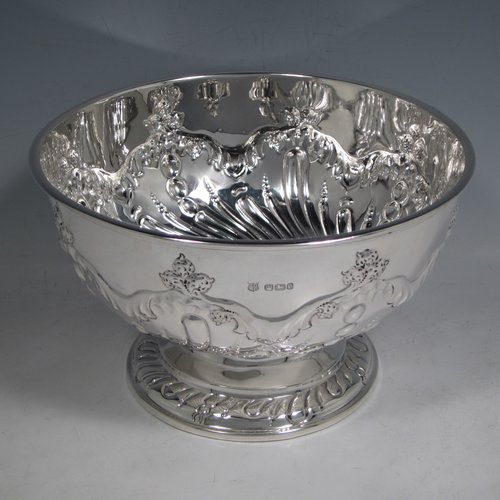 Antique Victorian sterling silver rose bowl, having a round hand-chased body with swirl fluted and floral decoration, and sitting on a pedestal foot. Made by the Deakin Brothers of Sheffield in 1897. The dimensions of this fine hand-made silver bowl are height 12 cms (4.75 inches), diameter 19.5 cms (7.75 inches), and it weighs approx. 391g (12.6 troy ounces).   