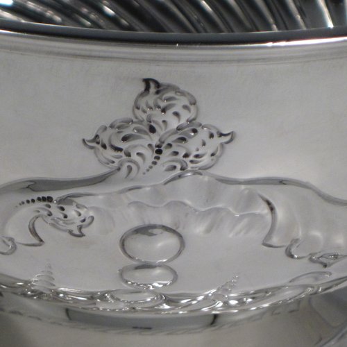 Antique Victorian sterling silver rose bowl, having a round hand-chased body with swirl fluted and floral decoration, and sitting on a pedestal foot. Made by the Deakin Brothers of Sheffield in 1897. The dimensions of this fine hand-made silver bowl are height 12 cms (4.75 inches), diameter 19.5 cms (7.75 inches), and it weighs approx. 391g (12.6 troy ounces).   