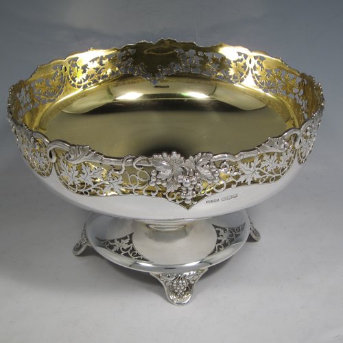 A Sterling silver table bowl, having a round body, with an applied and hand-pierced grape & vine-leaf border, with a gold-gilt interior, all sitting on a hand-pierced pedestal base with four hand-chased feet. Made by Olivant & Botsford of Sheffield in 1937. The dimensions of this fine hand-made silver bowl are diameter 21.5 cms (8.5 inches), height 14 cms (5.5 inches), and it weighs approx. 737g (23.8 troy ounces).   