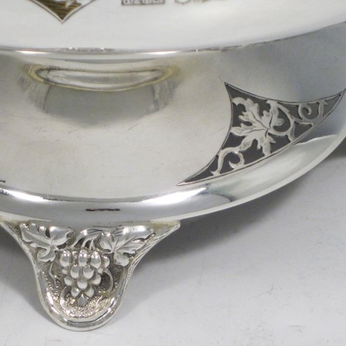 A Sterling silver table bowl, having a round body, with an applied and hand-pierced grape & vine-leaf border, with a gold-gilt interior, all sitting on a hand-pierced pedestal base with four hand-chased feet. Made by Olivant & Botsford of Sheffield in 1937. The dimensions of this fine hand-made silver bowl are diameter 21.5 cms (8.5 inches), height 14 cms (5.5 inches), and it weighs approx. 737g (23.8 troy ounces).   