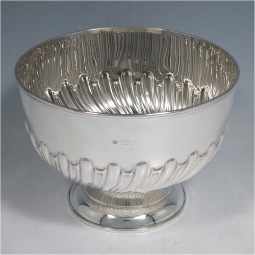 An Antique Victorian Sterling Silver Rose bowl, having a round hand-chased body with swirl half-fluted decoration, an applied reeded border, and sitting on a pedestal foot. Made by William Hutton & Sons of London in 1898. The dimensions of this fine hand-made silver bowl are height 11.5 cms (4.5 inches), diameter 16 cms (6.25 inches), and it weighs approx. 310g (10 troy ounces).   