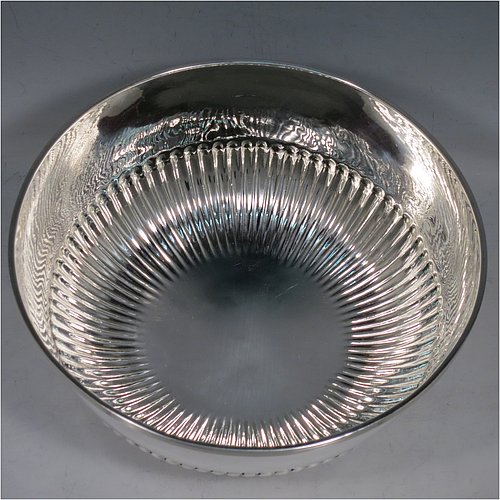 A rare Antique Georgian Sterling Silver Rose bowl, having a round body with hand-chased half-fluted decoration, an applied reeded border, and sitting on a collet foot. Made by John Robins of London in 1801. The dimensions of this fine hand-made silver bowl are height 8 cms (3.25 inches), diameter 18 cms (7 inches), and it weighs approx. 452g (14.6 troy ounces). Please note that this item is crested.    