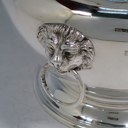 An Antique Victorian Sterling Silver table bowl, having a plain round bellied body with a hand-pierced top gallery border, together with two cast lion-mask and ring side-handles, and sitting on a plain round pedestal foot. Made by Gibson & Langland of London in 1899. The dimensions of this fine hand-made antique silver table bowl are diameter 18 cms (7 inches), height 14 cms (5.5 inches), and it weighs approx. 581g (18.7 troy ounces).    